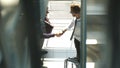 Full length side view of businessmen shaking hands in office building Royalty Free Stock Photo
