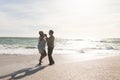 Full length side view of happy senior multiracial couple dancing romantically at beach on sunny day Royalty Free Stock Photo