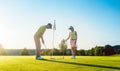 Man ready to hit the golf ball while exercising with his game partner Royalty Free Stock Photo