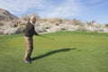 Full length side view of senior male golfer swinging his club at golf course Royalty Free Stock Photo