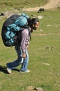 Full length side view of a young man walking in the mountain with carrying parachute backpack Royalty Free Stock Photo