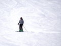Full length of skier skiing on fresh powder snow. Man skier running downhill on sunny Alps slope Royalty Free Stock Photo