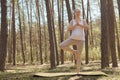 Full length of slim sporty athletic Caucasian pregnant woman doing sports exercising on mat standing in yoga pose and with praying Royalty Free Stock Photo