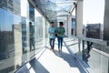 Full length of smiling african american colleagues discussing while walking in corridor at workplace Royalty Free Stock Photo