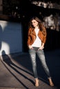 Smiling brunette in stylish spring look walking at street.