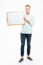 Full length of smiling young man holding blank whiteboard Royalty Free Stock Photo