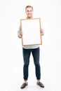 Full length of smiling young man holding blank whiteboard Royalty Free Stock Photo