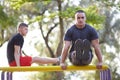 Two healthy men swings the press on a horizontal bar on a sports ground in the summer in the city. Royalty Free Stock Photo