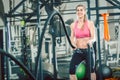 Full length of a strong and beautiful woman waving battle ropes at the gym Royalty Free Stock Photo