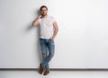 Full length studio portrait of casual young man in jeans and shirt. Isolated on white background.