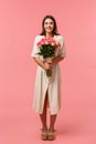 Full-length vertical portrait attractive, lovely young woman receiving beautiful flowers, holding bouquet enjoying Royalty Free Stock Photo