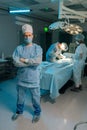 Full length vertical portrait of male doctor in surgical uniforms and masks standing posing looking at camera in Royalty Free Stock Photo