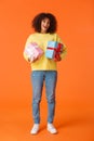 Full-length vertical shot excited cute happy african-american female received gifts for holidays, standing amused and