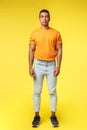 Full-length vertical shot masculine hipster guy, hispanic ethnicity, standing casually yellow background, wear stylish