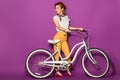 full length view of beautiful smiling stylish asian girl standing with bike and looking away Royalty Free Stock Photo