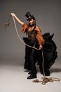 Length view of beautiful steampunk woman holding lasso on grey