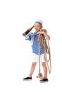 Length view of focused preschooler child in sailor costume looking in spyglass and holding rope isolated on white