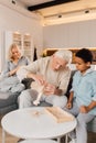 Grandfather telling something to his son while holding model of the airplane