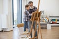 Child enjoying art making with grandpa in home studio