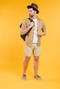 full length view of handsome young man in shorts and hat holding backpack and looking away Royalty Free Stock Photo