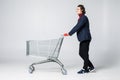 Full length view of handsome young man standing with shopping trolley isolated on white background Royalty Free Stock Photo