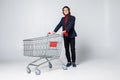 Full length view of handsome young man standing with shopping trolley isolated on white background Royalty Free Stock Photo