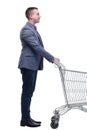 Full length view of handsome young man standing with shopping trolley and looking at camera Royalty Free Stock Photo