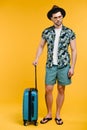full length view of handsome young man in summer outfit holding suitcase Royalty Free Stock Photo