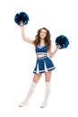 Length view of happy cheerleader girl in blue uniform dancing with pompoms isolated on white