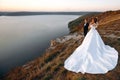 Full length view of the happy wedding couple on the edge of the world