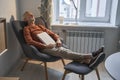 Male reader taking nap at comfortable armchair at home during the evening Royalty Free Stock Photo