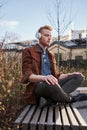 Man wearing headphones keeping eyes closed while sitting in yoga position Royalty Free Stock Photo