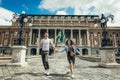 Full-length view of the pretty young couple in love holding hands while walking along the countryard at the Buda Castle Royalty Free Stock Photo