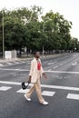 Full length view of a stylish young african american adult woman holding her purse looking forward crossing the street in the city