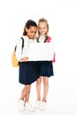 full length view of two multicultural schoolgirls using laptop isolated on white. Royalty Free Stock Photo