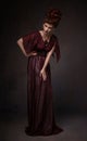 Full length view of woman with baroque hairstyle and evening maroon dress