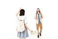 Full length view of young man walking to girl, who waiving her hand and holding map Royalty Free Stock Photo