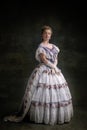 Full-length vintage portrait of young adorable girl in image of medieval royal person in renaissance style dress