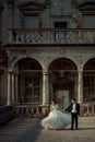 Full-length wedding portrait of the dancing newlywed couple on the balcony of the old castle. Royalty Free Stock Photo