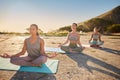 Full length yoga women meditating with legs crossed for outdoor practice in remote nature. Diverse group of mindful