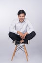 Full length of a young asian casual man sitting on a chair over Royalty Free Stock Photo
