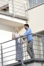 Full length of young business couple conversing at hotel balcony