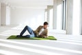 Full length of young businessman using tablet computer while reclining on turf in office Royalty Free Stock Photo