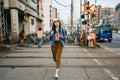 Full length of young girl traveler walking pass cross the railway. elegant lady tourist backpacker trip in osaka japan alone.