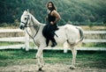 Full length of young handsome man sitting on his white stallion at the country side. Man equestrian on his horse riding Royalty Free Stock Photo