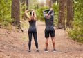 Full length of a young male and female athlete stretching before a run outside in nature from behind. Two fit Royalty Free Stock Photo