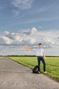 Full length of young man holding anywhere sign on empty road