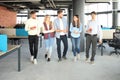 Full length of young people in smart casual wear discussing business and smiling while walking through the office. Royalty Free Stock Photo