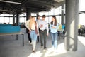 Full length of young people in smart casual wear discussing business and smiling while walking through the office. Royalty Free Stock Photo