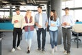 Full length of young people in smart casual wear discussing business and smiling while walking through the office. Royalty Free Stock Photo